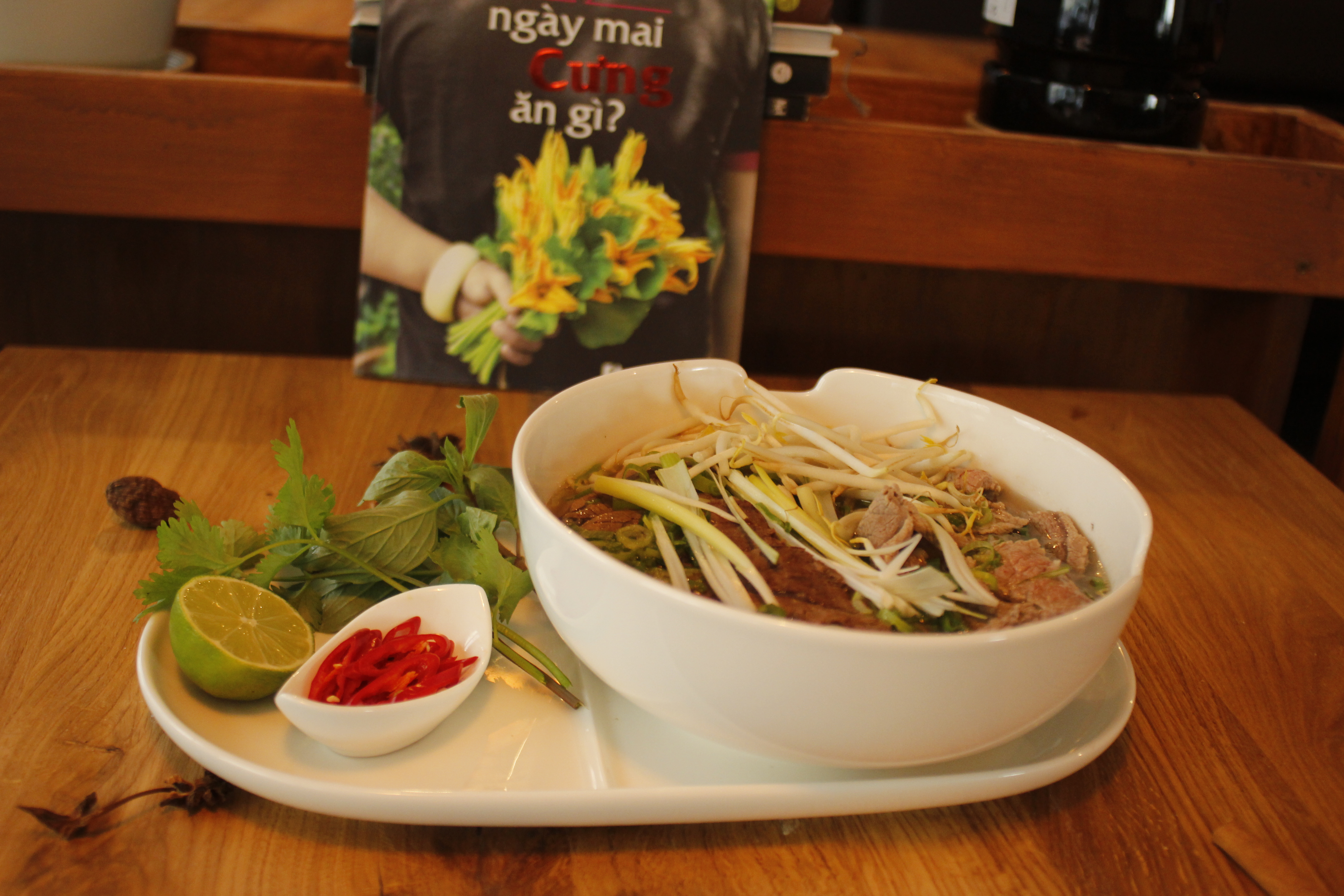 Beliebte vietnamesische Reisbandnudelsuppe mit klarer würzige Rinderbrühe serviert mit Sojasprossen, frischen Limetten, Koriander und Frühlingszwiebeln